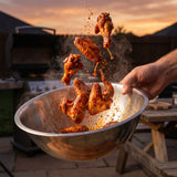 Heavenly Hell Cluckin Hell hot chicken rub 150g — spicy chicken wings tossed mid-air in a steel bowl with rub in the air