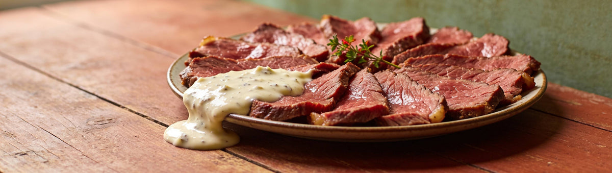 Strong Horseradish Cream lifestyle banner — sliced roast beef with horseradish cream