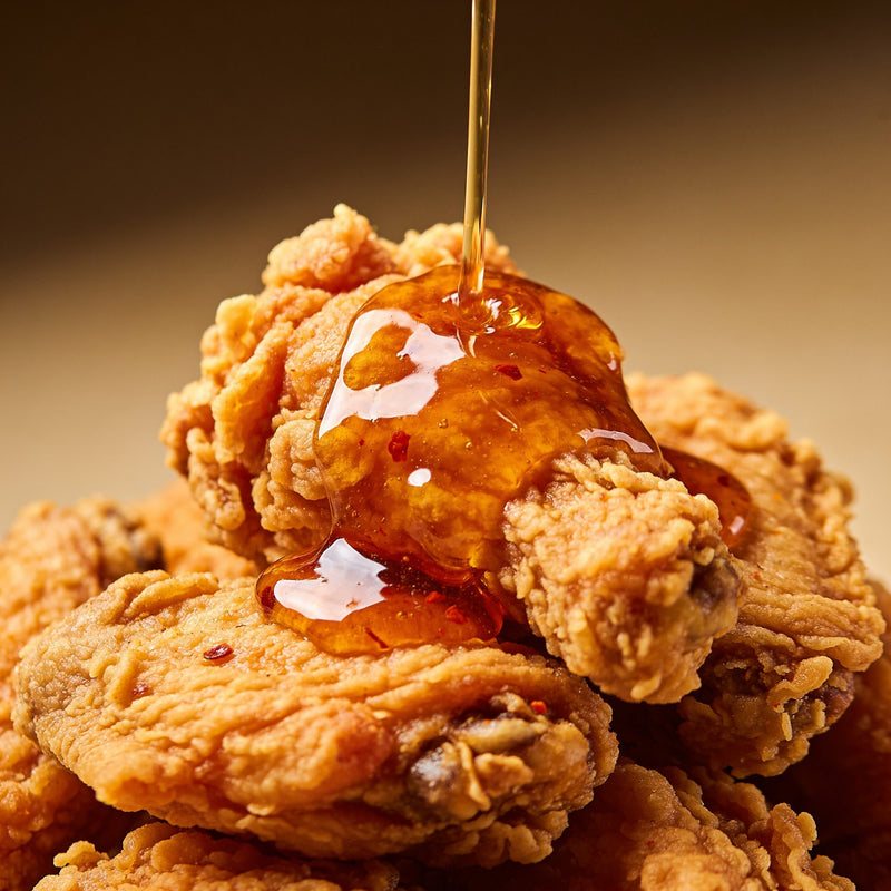 Fiery hot honey drizzle over fried chicken lifestyle photo