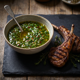 Elk Creek Chimi-Churri — a bowl of vibrant green chimichurri beside grilled lamb cutlets