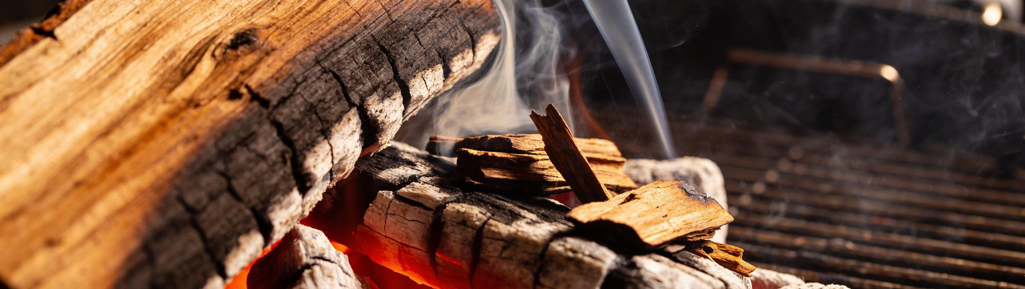 Jack Daniel's Whiskey Barrel Smoking Chips banner background — charred oak chips smoking over glowing coals
