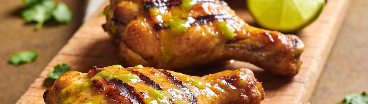 Chicken drumsticks with lime wedges, warm backyard bokeh
