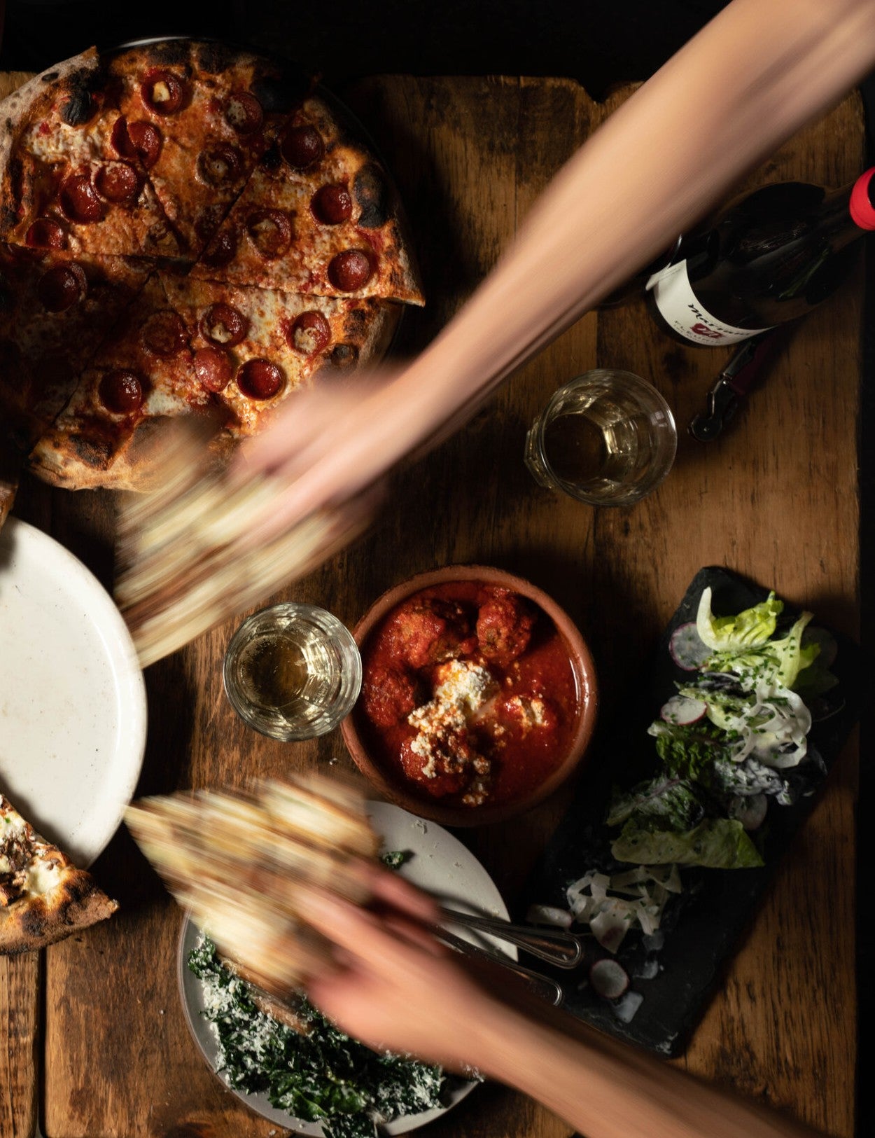 The Joy of Pizza by Dan Richer & Katie Parla hardback cookbook — table of Razza pizzas being shared