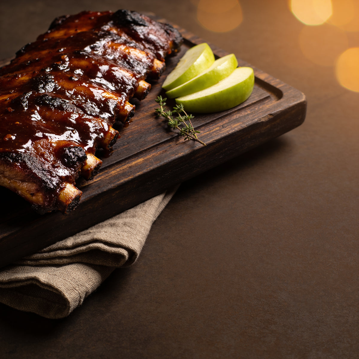 Kosmos Q Apple Chipotle BBQ Sauce glazed pork ribs, deep rich mahogany glaze with green apple slices