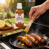 Brushing Lillie's Q Gold mustard Barbeque Sauce onto grilled hot-link sausages