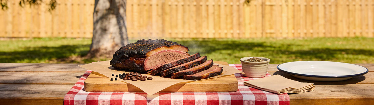 Low n Slow Basics Beef Bounce coffee rub banner with smoked brisket and short ribs over open flame