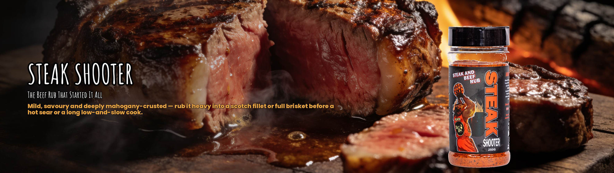 Low n Slow Basics Steak Shooter beef rub banner with a seared scotch fillet steak on a wooden board over open flame