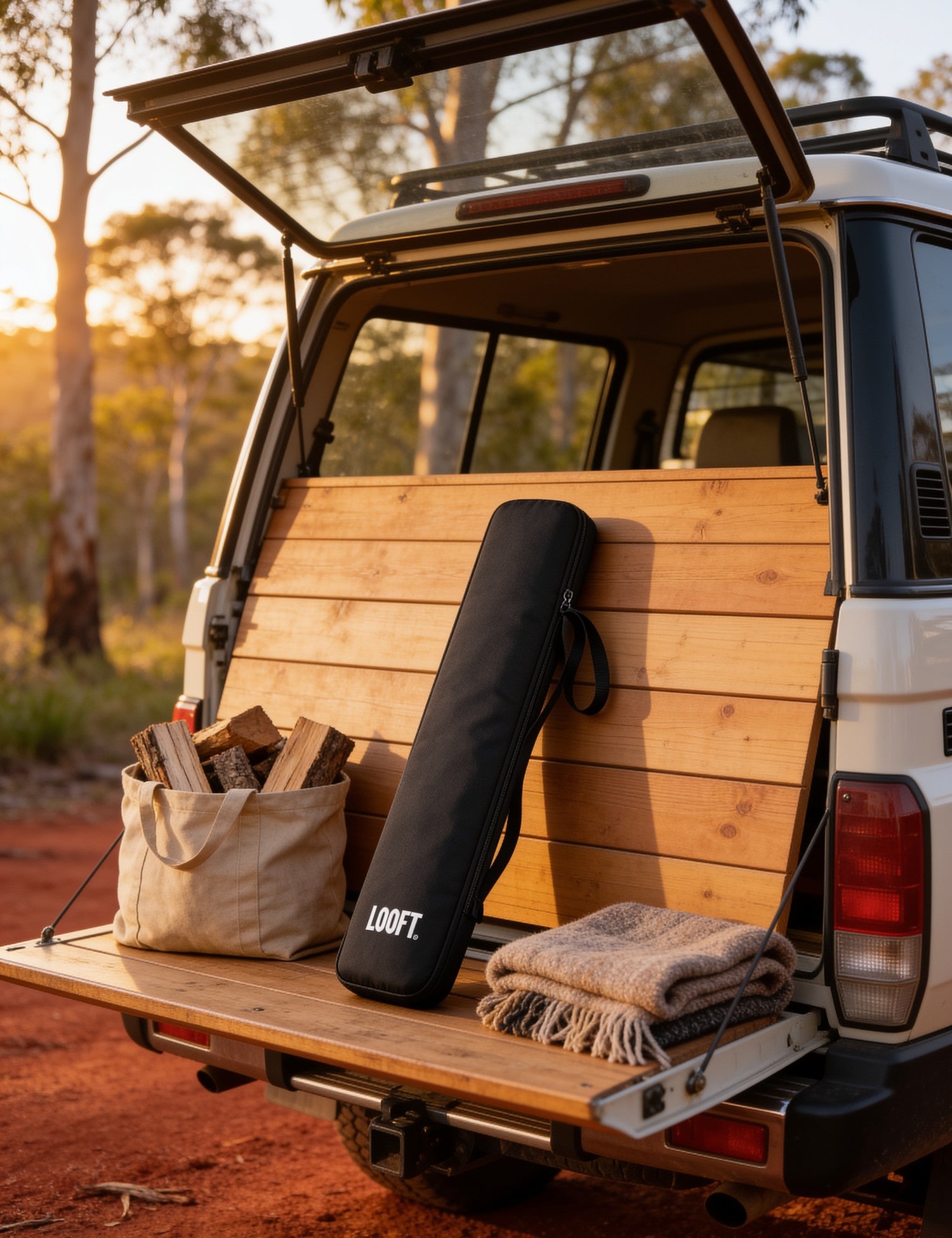 Looftlighter carry case packed in a ute at a bush campsite with firewood