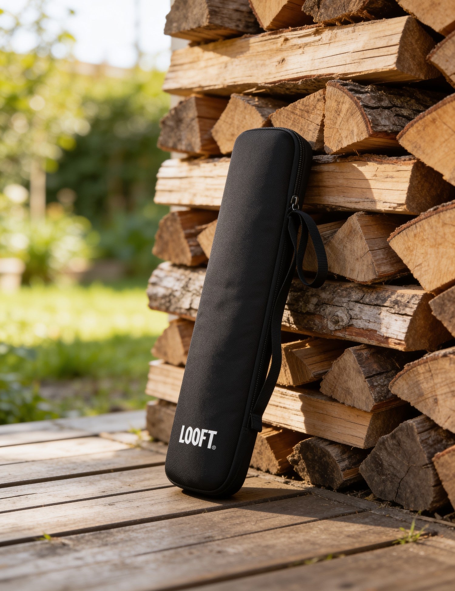 Looftlighter carry case leaning against stacked firewood on a timber deck