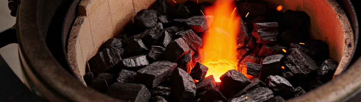 Looftlighter Classic electric fire starter beside lump charcoal catching in a kamado firebox