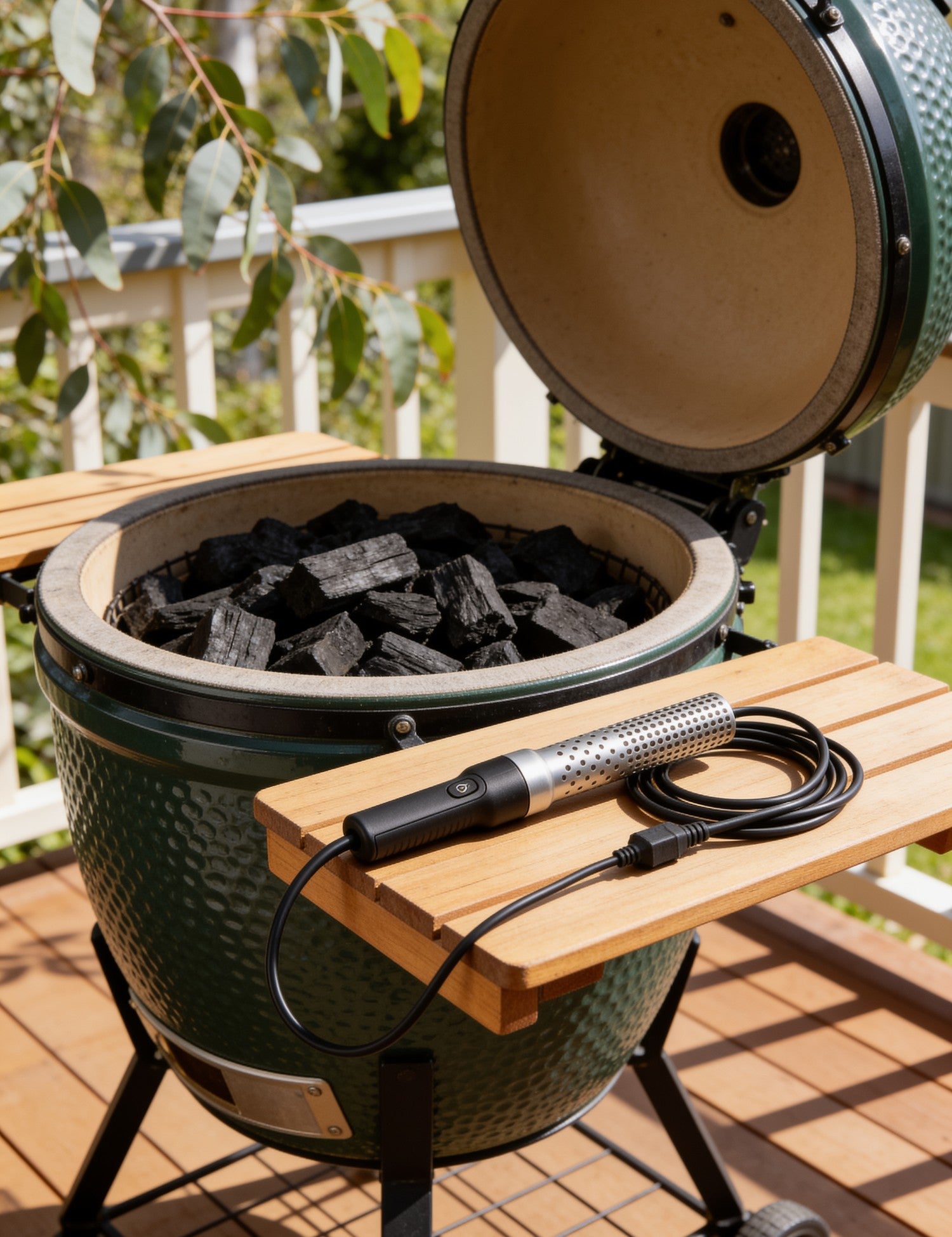 Looftlighter Classic electric charcoal starter resting on a kamado side shelf beside a load of lump charcoal