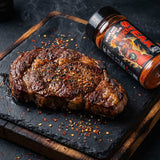 Low n Slow Basics Steak Shooter Spicy beef rub — a grilled ribeye steak with a spiced crust and chilli flakes on a slate board