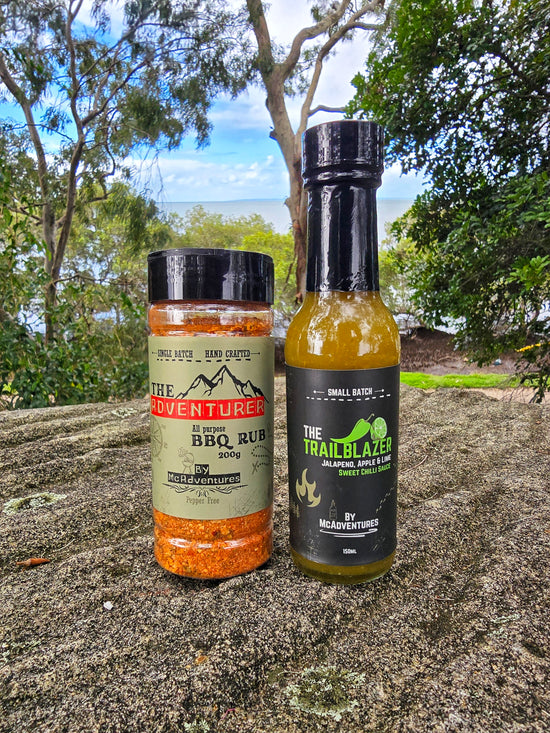 McAdventures The Expedition Pack — Adventurer rub and Trailblazer sauce together on coastal rock — lifestyle
