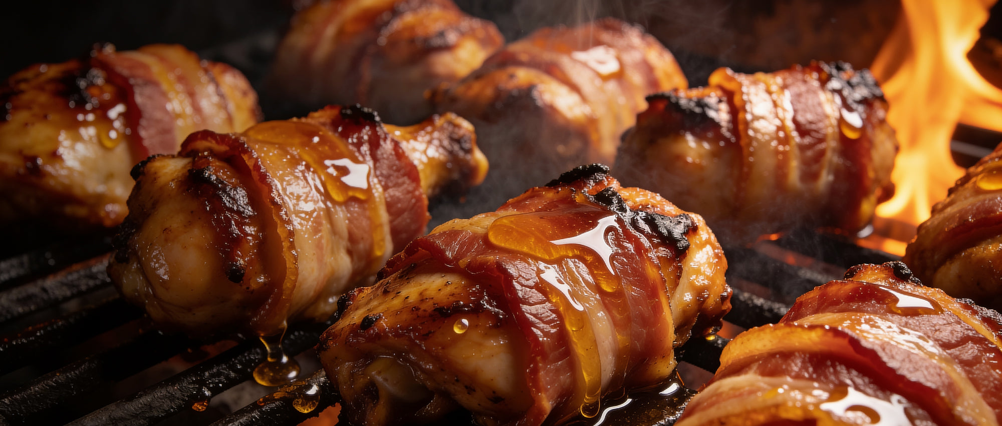 Meat Church Honey Bacon BBQ Rub — bacon-wrapped chicken thighs glazed and smoking on a grill grate