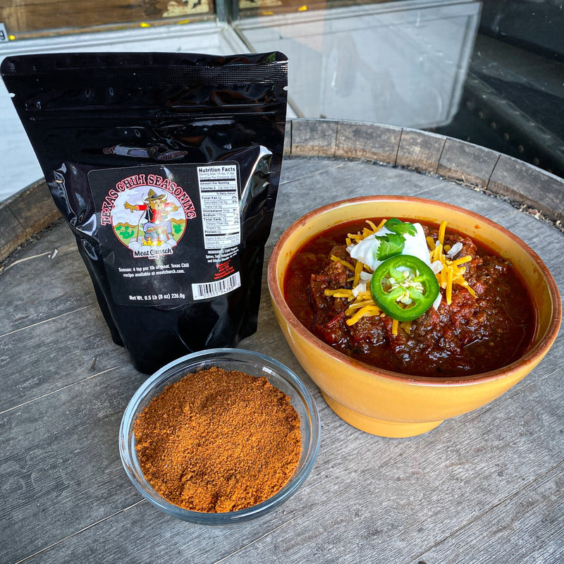 Meat Church Texas Chili topped with sour cream, cheese and jalapeño in a bowl lifestyle photo