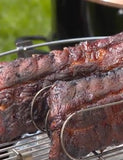 Meathead by Meathead Goldwyn hardback cookbook — two racks of glazed smoked ribs on a rib rack over the grill