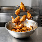 Middle Kingdom Chicken Chieftain 160g chicken seasoning — crisp golden chicken wings caught mid-toss above a steel bowl