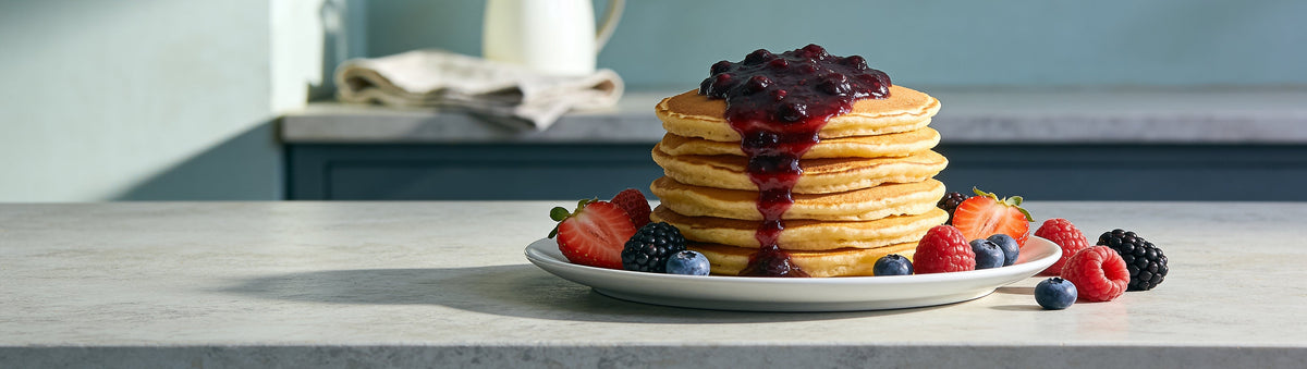 Mitch's Preserves Fourberries Jam: Pancake stack with four-berry jam and fresh berries on a stone kitchen bench