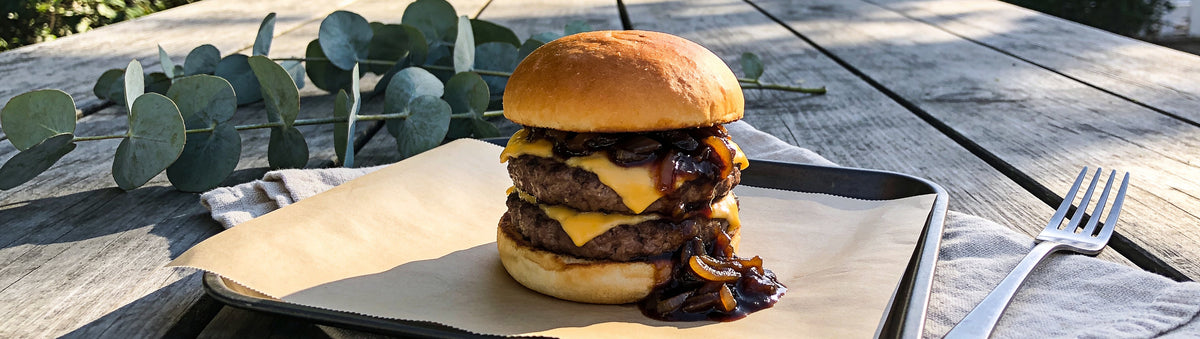 Mitch's Preserves Onion Jam: Cheeseburger piled with sticky onion jam on a garden picnic table