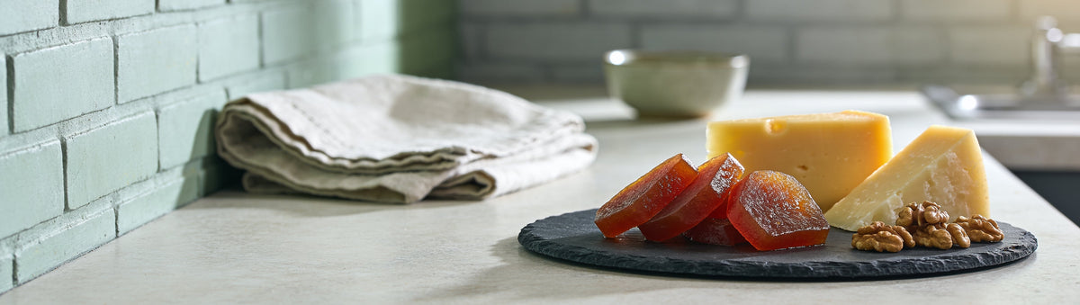 Mitch's Preserves Quince Paste: Quince paste slices with aged cheddar, pecorino and walnuts on a slate board