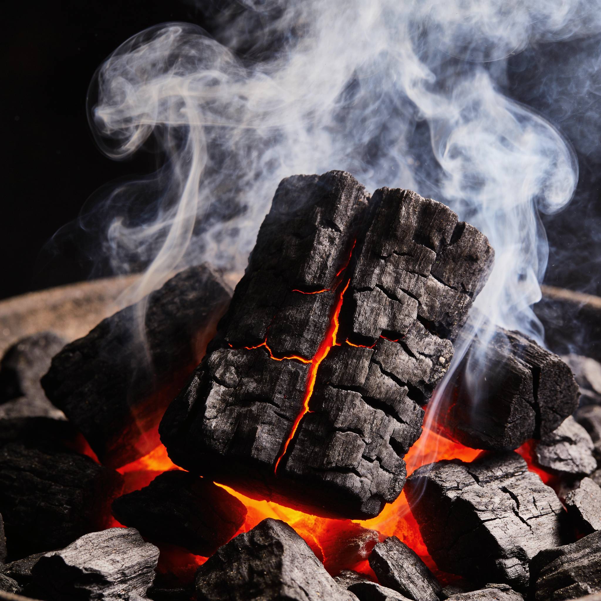 Natural Smoke Ironbark wood chunks smoking on hot coals