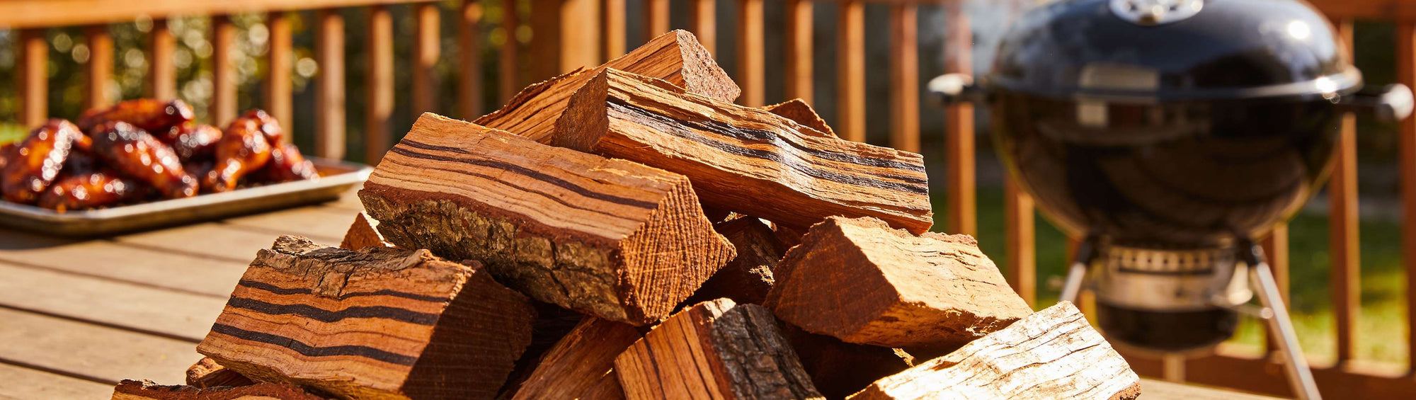 Pecan wood chunks piled with a gentle smoke curling upward