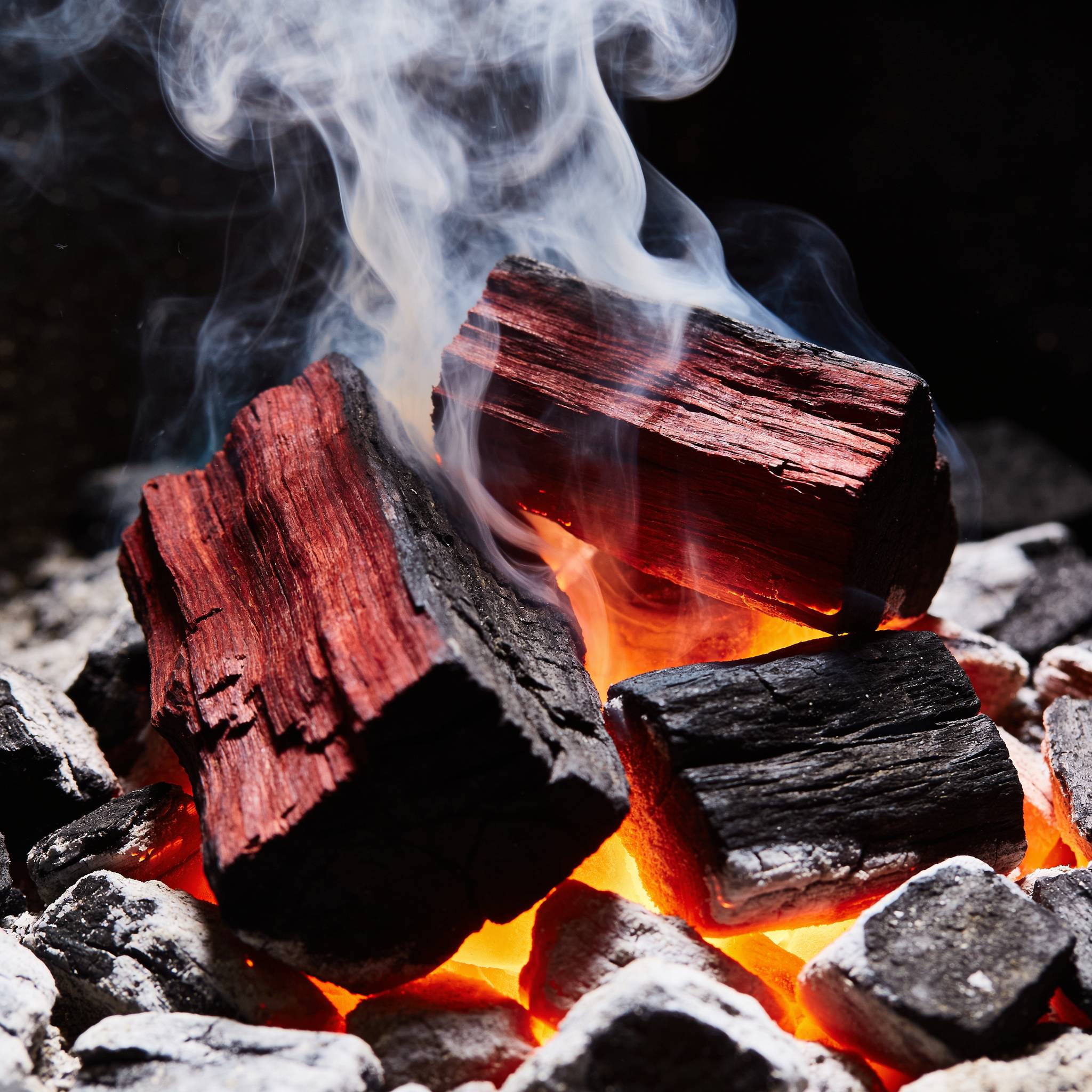 Natural Smoke Red Gum wood chunks smoking on hot coals