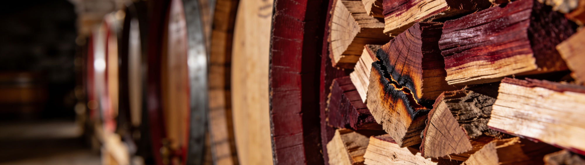 Wine-stained wood chunks with a deep burgundy tinge in soft natural light