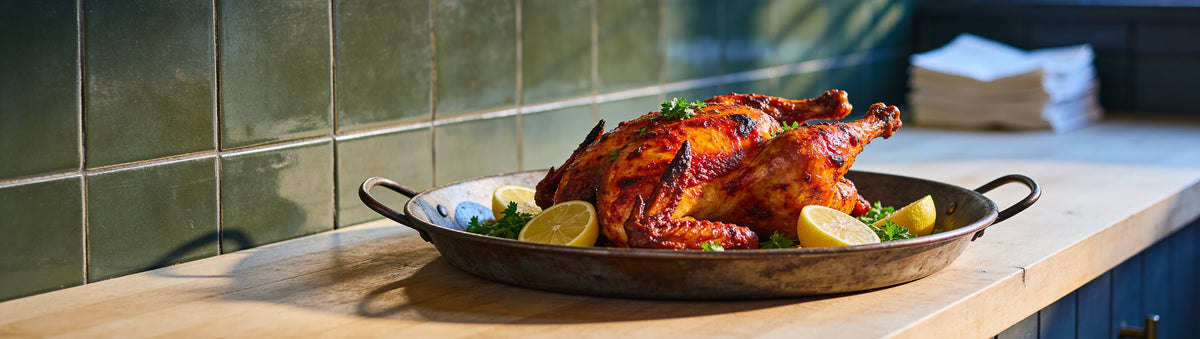 Peri peri chicken with lemon on a green-tiled counter – Old Bones Chilli Co Peri Peri Sauce
