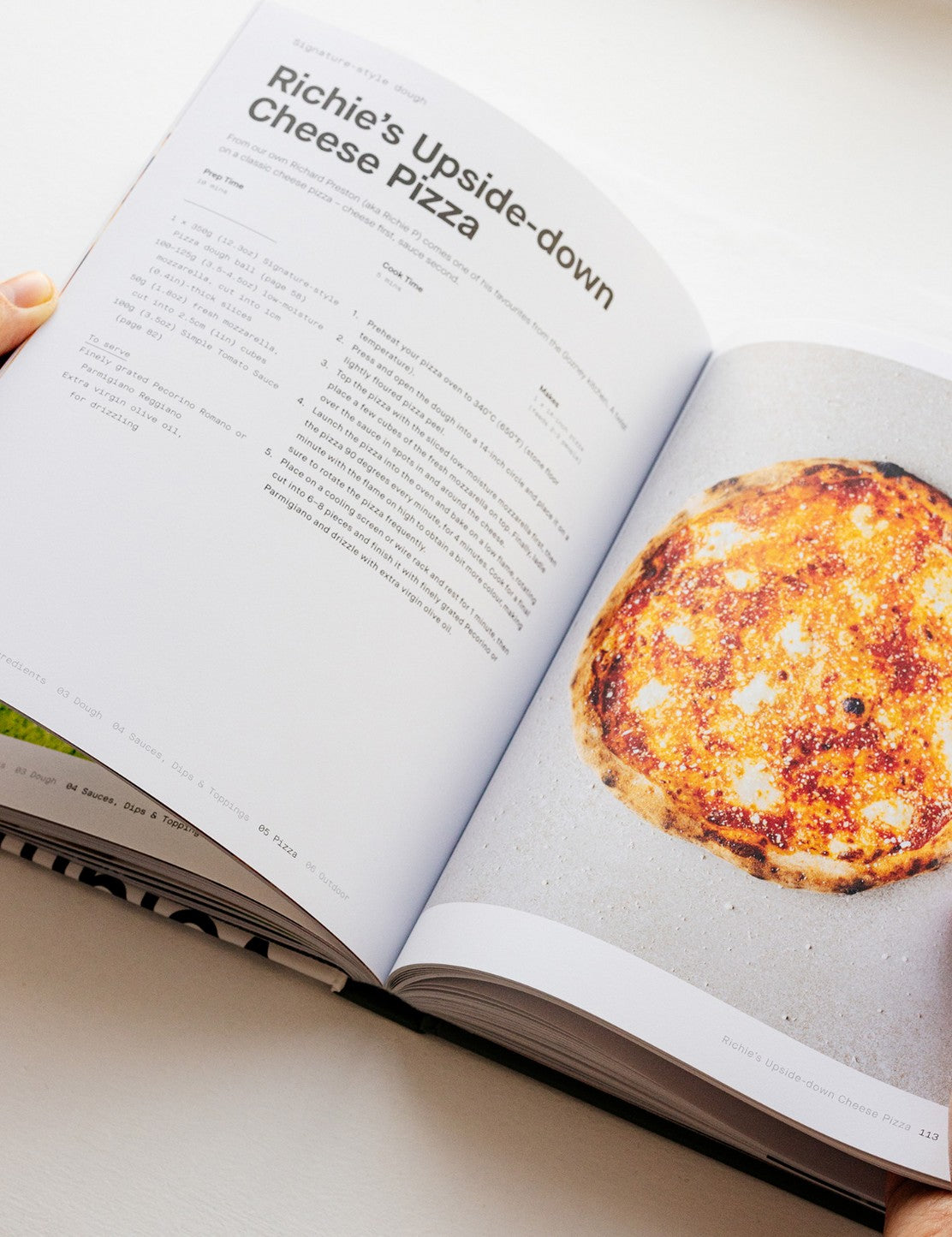 Pizza Volume 01 by Gozney hardback cookbook — open spread of an upside-down cheese pizza recipe