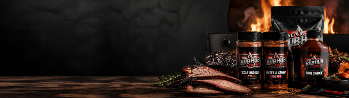 The Rub Hub BBQ rubs and sauce beside sliced smoked brisket in front of a fire-lit smoker
