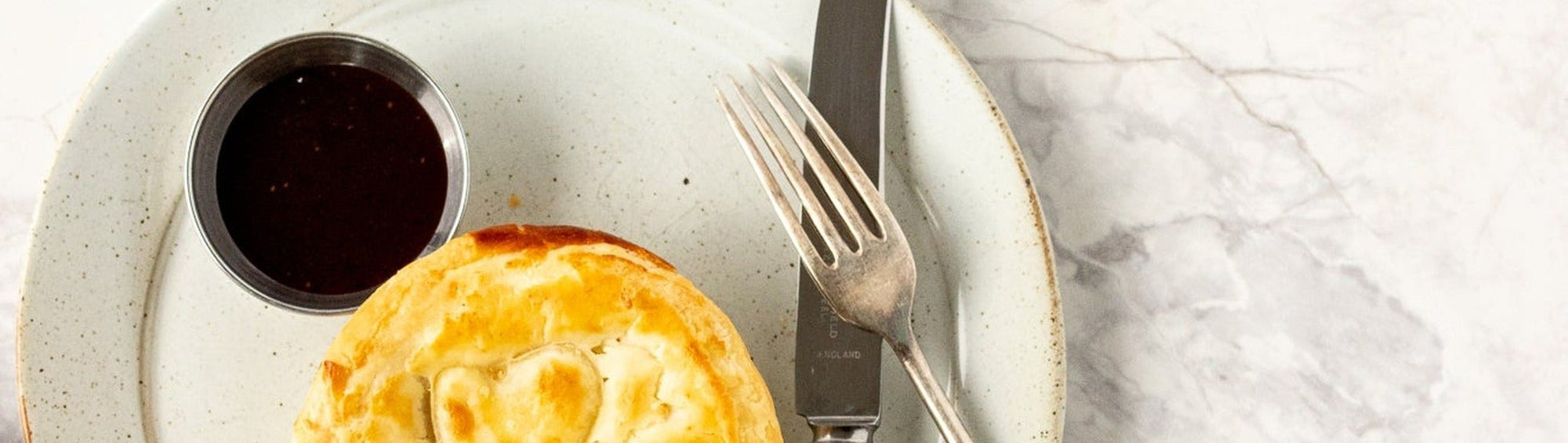 Rum and Que Meat Juice Glaze & BBQ Sauce banner — golden meat pie with a side of glaze