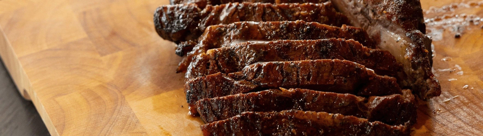 Rum and Que Umami Port & Black Garlic Sauce banner — sliced smoked beef brisket on a wood board