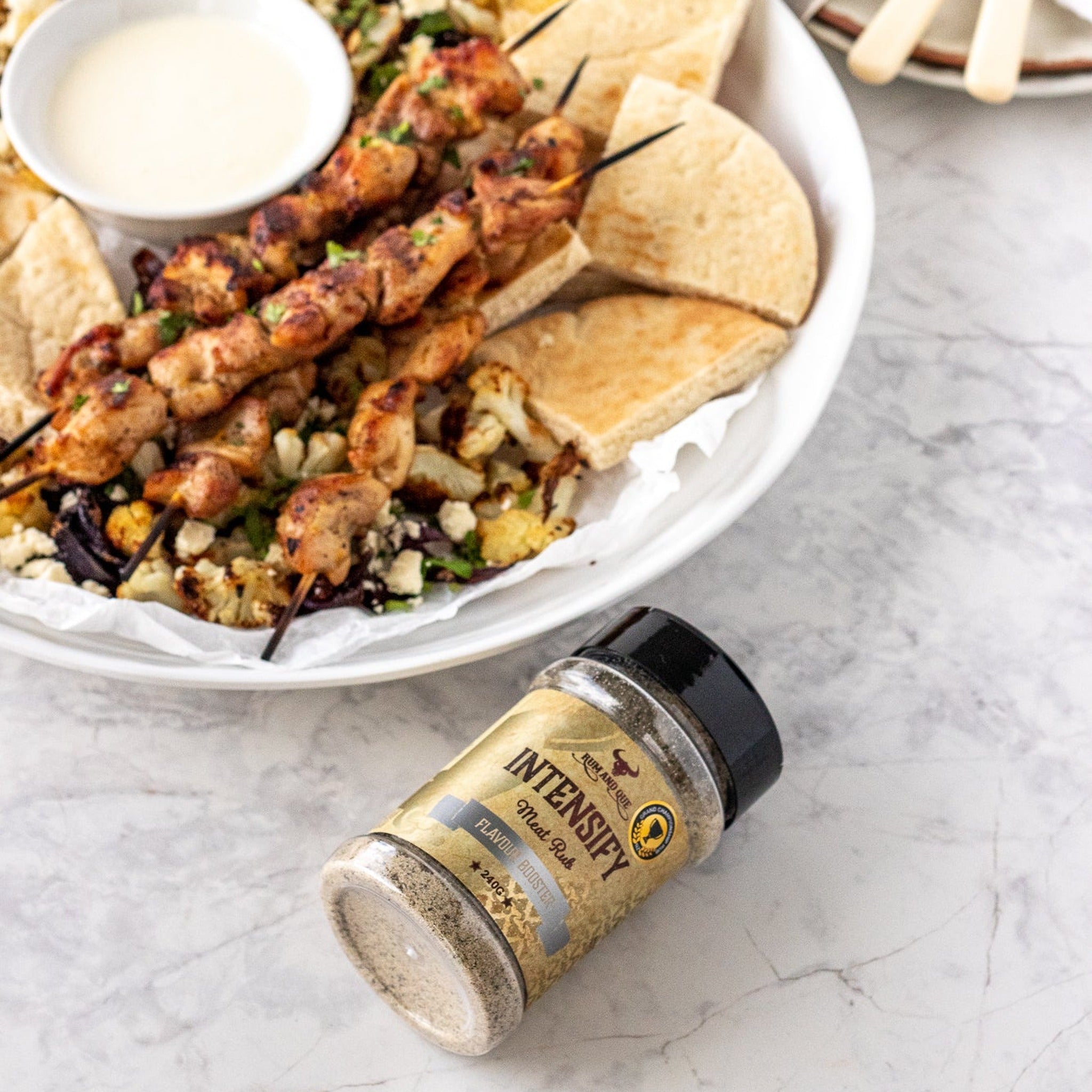 Rum and Que Intensify all purpose rub — chicken skewers with flatbread and dip, shaker alongside