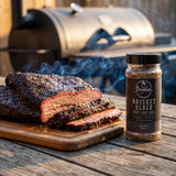 Smokes Brisket Black beef BBQ rub — sliced smoked brisket with a dark coffee-pepper bark and pink smoke ring on a board