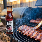 Smoky Pastures Sweet and Sour BBQ sauce — pork ribs mopped with sauce on the smoker