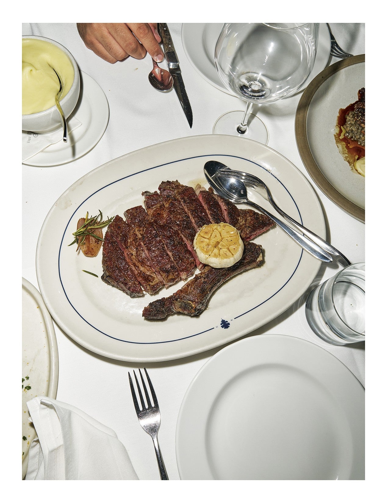 Steak House by Eric Wareheim & Gabe Ulla hardback cookbook — interior page of rib eye with roasted garlic