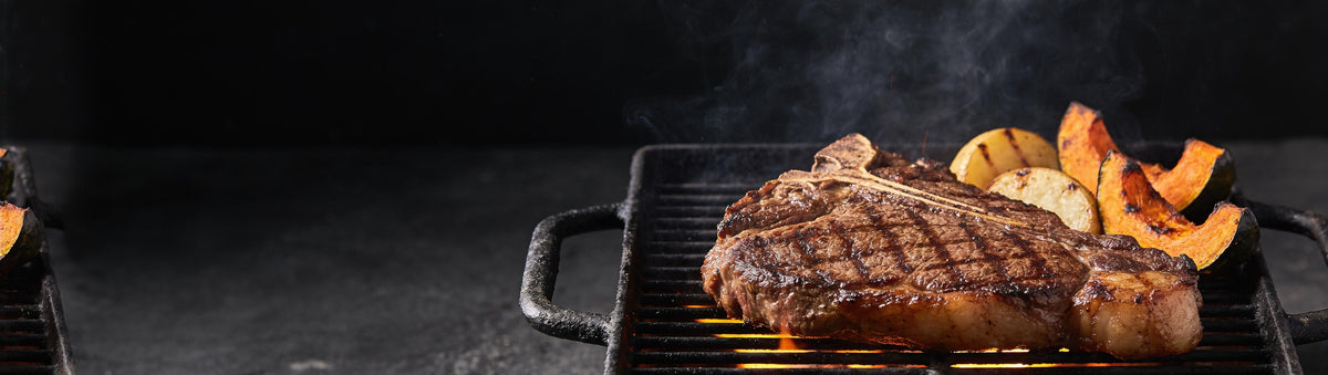 Stef the Maori Rub One Out All Purpose Seasoning 240g banner — thick scotch fillet steak and roast potato and pumpkin wedges searing on a cast-iron grill over open flame