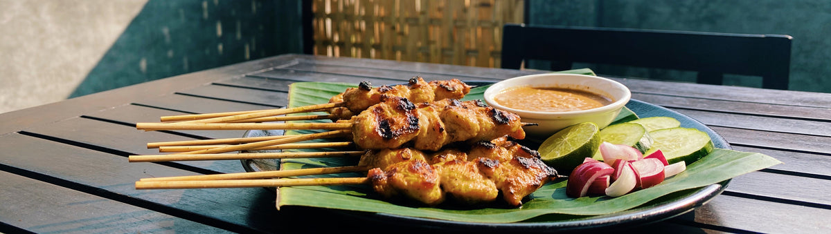 Chicken satay skewers with peanut sauce on a banana leaf, made with Street BBQ Balinese Satay Rub
