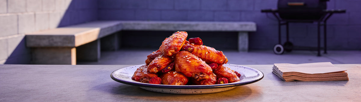 Sticky chilli-glazed chicken wings with sesame on an enamel plate – Taipan BBQ Bubblegum BBQ Sauce