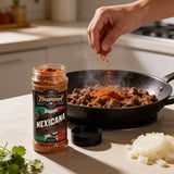 TAIPAN BBQ Mexicana taco seasoning 175g — in-use shot, sprinkling seasoning over sizzling taco mince