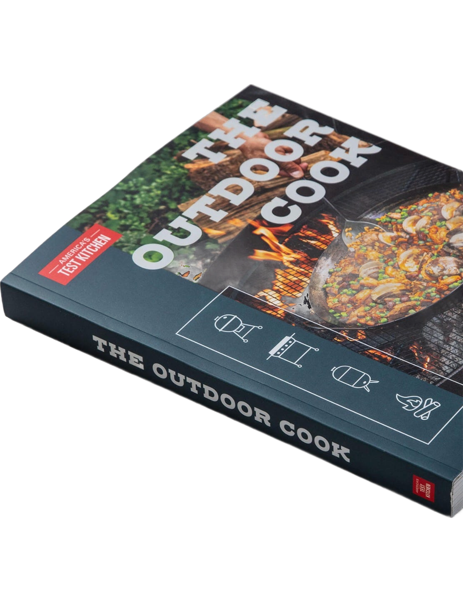 The Outdoor Cook by America's Test Kitchen paperback cookbook — angled shot of the book on concrete