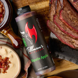 Tillman's Barbecue Chipotle Apple BBQ sauce bottle styled on a board with sliced brisket, baked beans and dip