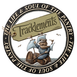 Tracklements brand logo, navy circular badge of a sailor on a barrel raft with a hangtag, on transparent background.