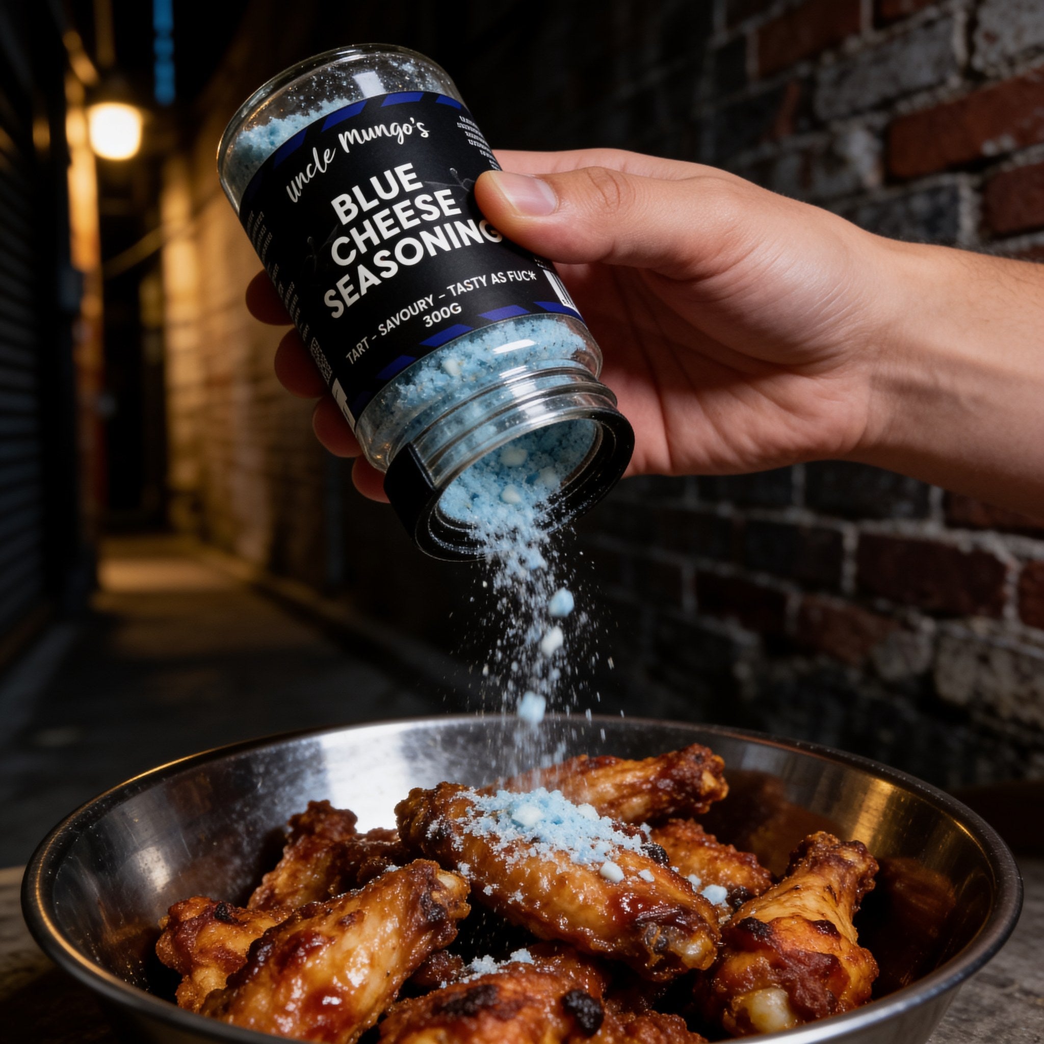Uncle Mungo's Blue Cheese Seasoning 300g blue cheese seasoning — shaking blue cheese seasoning over hot chicken wings