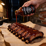 Uncle Mungo's Chipotle BBQ 200ml BBQ sauce — pouring chipotle BBQ sauce over smoked pork ribs