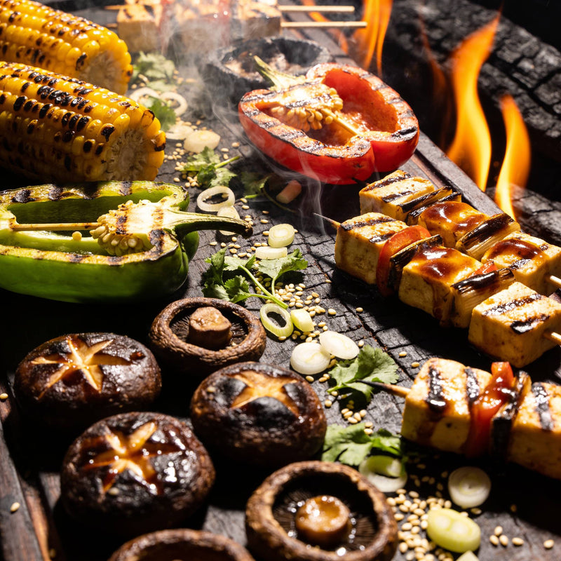 Grilled vegan tofu skewers, corn and vegetables over open flame lifestyle photo