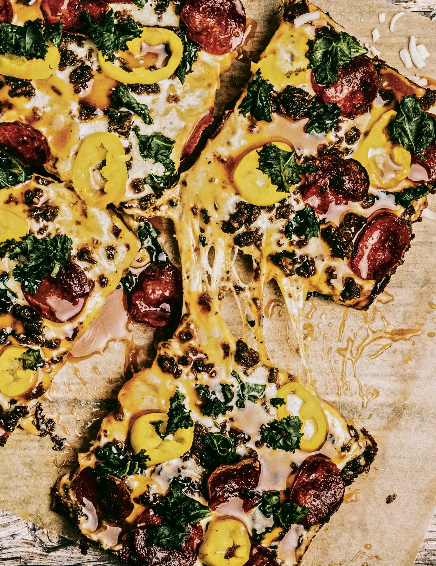 We the Pizza by Muhammad Abdul-Hadi hardback cookbook — interior page of square pizzas with pepperoni and greens